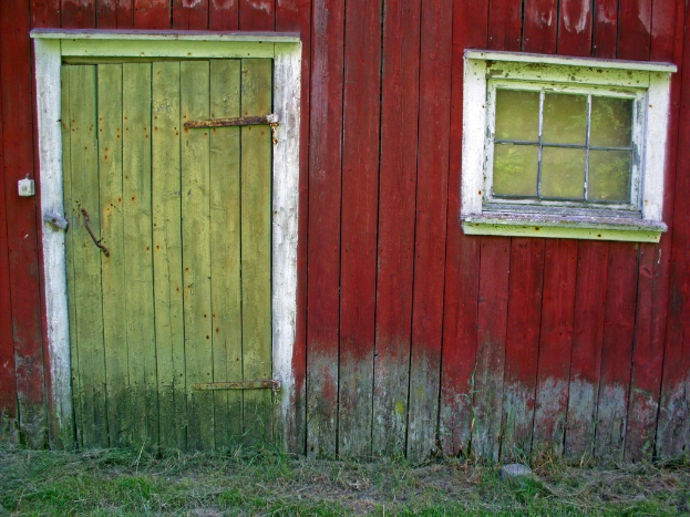 Ein hölzernes Haus mit einer hölzernen Tür auf der linken Seite und einem Glasfenster auf der rechten Seite.