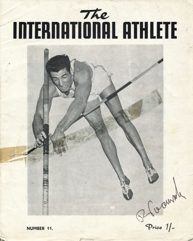 Ein Schwarz-Weiß-Foto eines Mannes in einem Trainingsanzug, der über eine Stange springt, mit den Worten "Der internationale Athlet" oben und unten auf dem Bild.