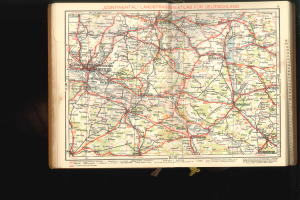 Ein aufgeschlagenes Buch mit einer detaillierten Deutschlandkarte, die auf einem dunklen Hintergrund dargestellt ist.