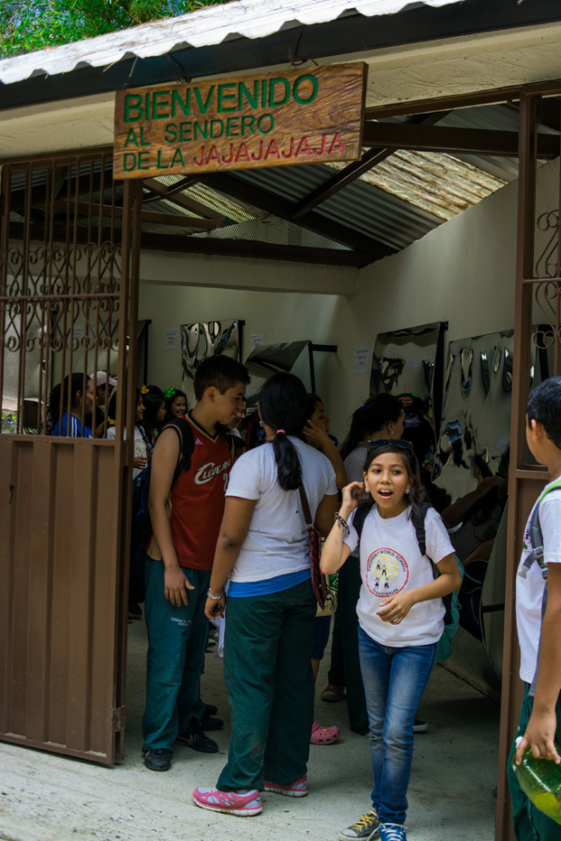 Ein Geschäft mit einer Eisenblechfassade, das ein Schild mit Text oben drauf hat und Menschen drinnen.