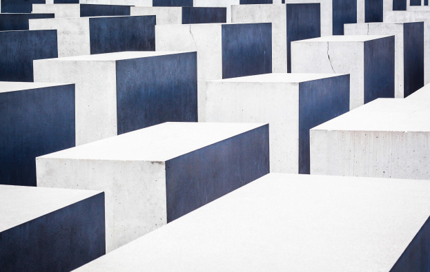Luftaufnahme des Holocaust-Mahnmals für die ermordeten Juden Europas in Berlin, das zahlreiche rechteckige Betonsteine in einem Gittermuster zeigt.