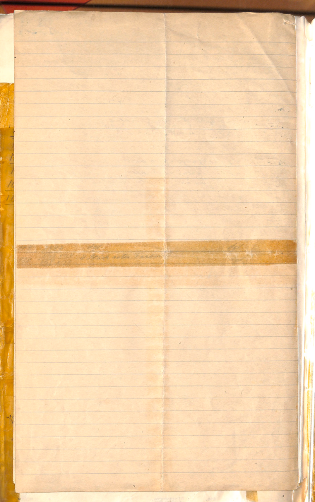 Ein aufgeschlagenes Buch mit einem linierten Blatt Papier darauf, das auf einer roten Oberfläche liegt.