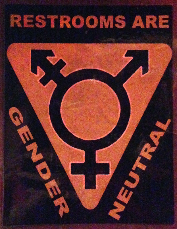 Ein Plakat mit der Aufschrift 'Toiletten sind geschlechtsneutral' betont die Bedeutung des Geschlechts auf der Toilette.