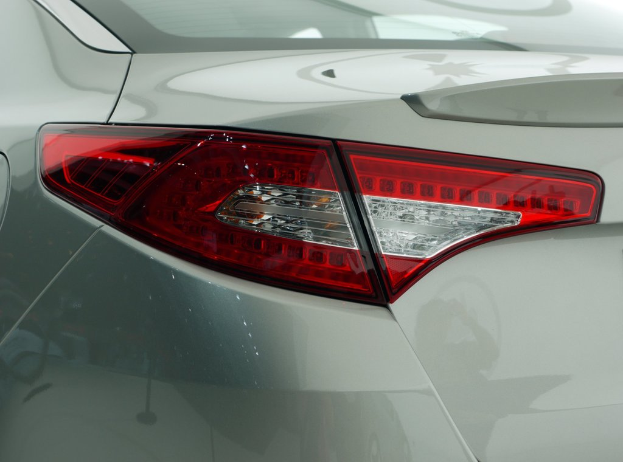 Eine Nahaufnahme des Heckbereichs eines Autos, die eine rote Bremsleuchte zeigt.