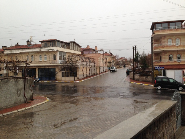 Motorisierte Fahrzeuge auf Straßen, Gebäuden, Bäumen, Strommasten, Kabeln, Geländern und Himmel in der Szene sichtbar.