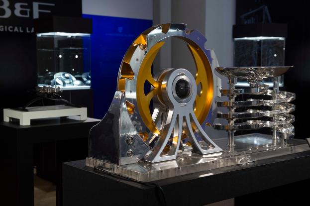 Ein Metallgetriebe und Metallausrüstung sind auf einem Tisch mit einer Wand im Hintergrund angeordnet.