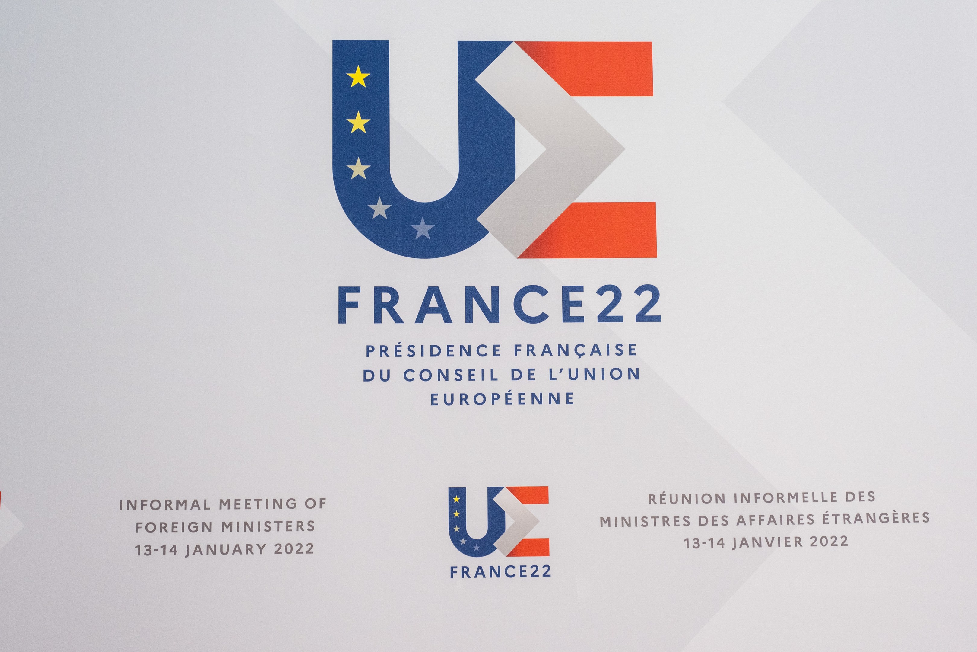 Plakat für das "Frankreich 22 - Informelle Tagung der ausländischen Minister" mit dem Logo der Europäischen Union, das einen blauen Kreis, einen weißen Stern und einen weißen Rahmen zeigt.