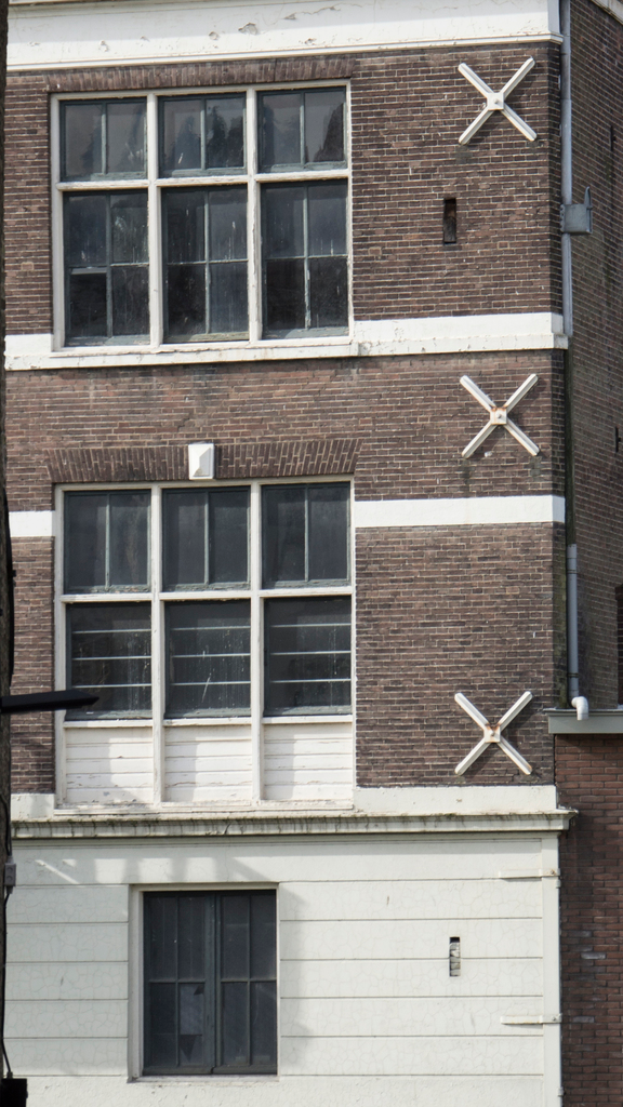 Ein Gebäude mit mehreren Fenstern und sichtbaren Rohren an seiner Fassade.