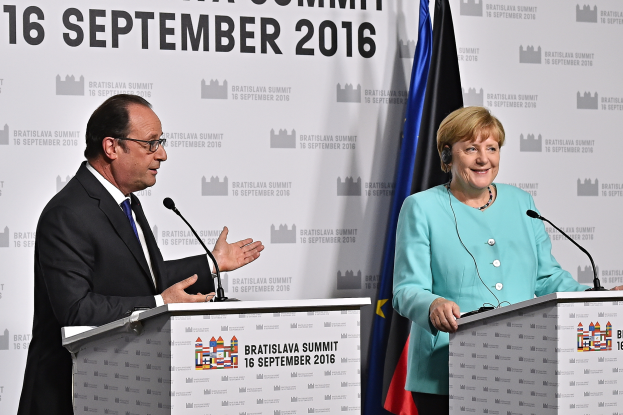 Bundeskanzlerin Angela Merkel und Frankreichs Präsident François Hollande stehen an Podien mit Mikrofonen, lächeln und haben ein "Bratislava Summit 2016"-Plakat im Hintergrund.