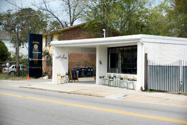Ein Restaurantgebäude, das an einer Straße entlang verläuft, mit Bäumen im Hintergrund.
