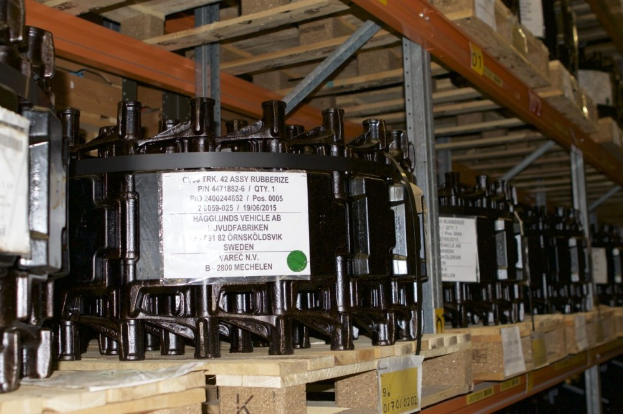 Ein Lagerraum voller metallener Objekte auf Holzpaletten, jeweils mit einem Aufkleber, der Teil eines Verteilgehäuses zu sein scheint, mit verschiedenen sichtbaren Komponenten.