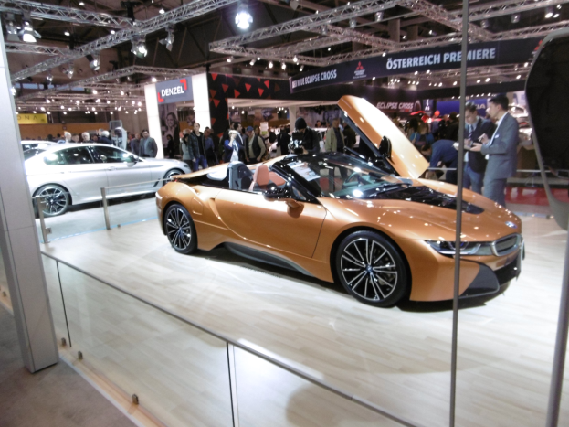 Ein schickes schwarzes BMW i8 Cabrio mit Chromakzenten auf der Frankfurter Motor Show umgeben von formell gekleideten Besuchern.