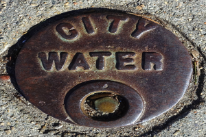 Ein Metall-Schachtobjekt auf dem Boden mit der Aufschrift "Stadtwasser".