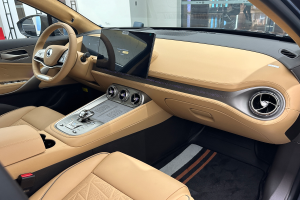 Das Innere eines Mercedes-Benz S-Klasse Limousinen auf der Frankfurter Automobilausstellung, mit einem Lenkrad, Armaturenbrett, Bildschirmen, Knöpfen, Sitzen, Seitenspiegeln und Glasfenstern, durch die Menschen, Gebäude und andere Gegenstände im Hintergrund zu sehen sind.