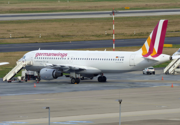 Ein Airbus A320-200 der Germanwings steht auf dem Frankfurt Airport, mit Fahrzeugen, Verkehrskegeln, Pfosten und Gras im Hintergrund.