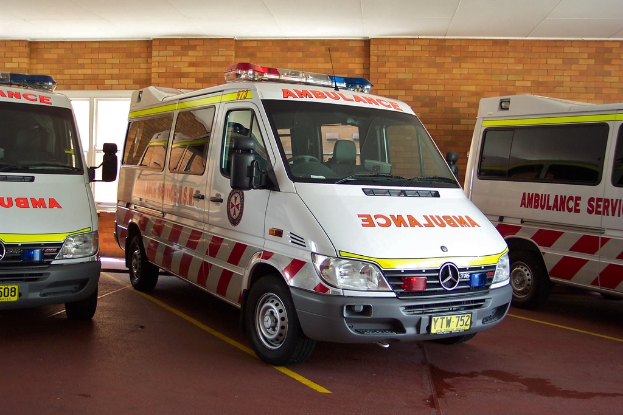 Ein Rettungswagen in Weiß vor einer Backsteinwand geparkt.