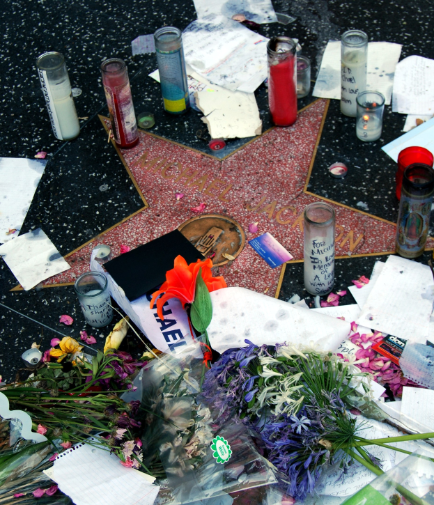 Star auf dem Hollywood Walk of Fame umgeben von Blumen, Kerzen, Papieren und anderen Hommagen.