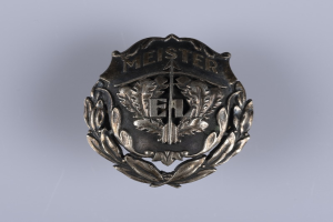 Ein silbergerändertes Abzeichen mit einem Lorbeerkranz, das die deutsche Armee repräsentiert, mit einer Inschrift.