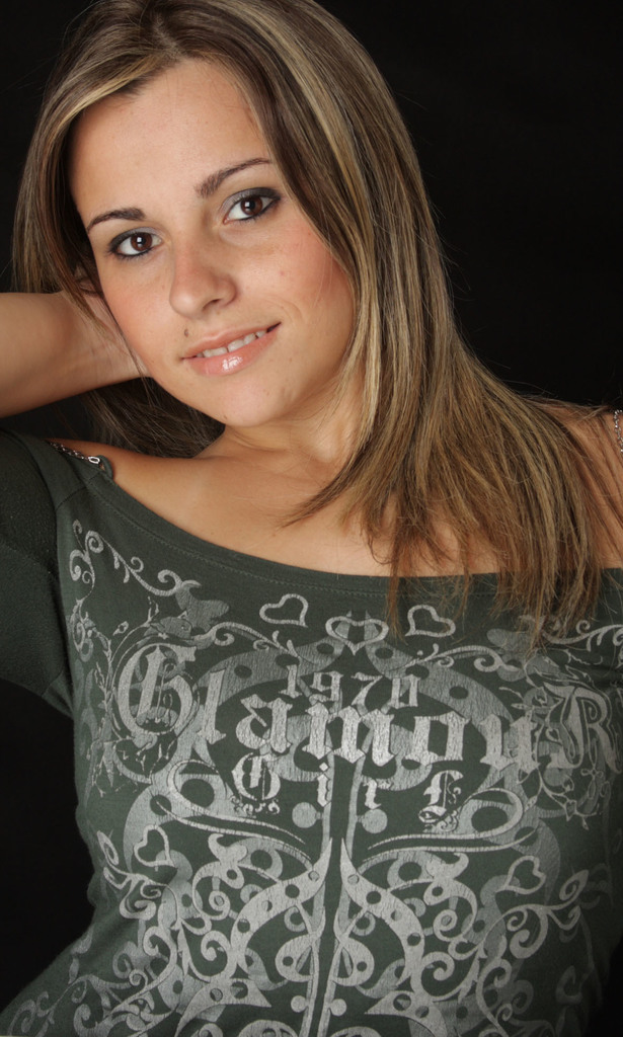 Eine Frau in einem grünen Kleid mit Designs posiert vor der Kamera.