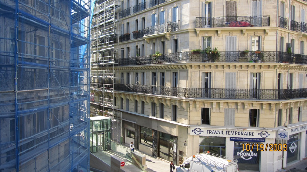 Ein großes Gebäude in Bau auf der linken Seite, mit einem Geschäft auf der rechten Seite unten